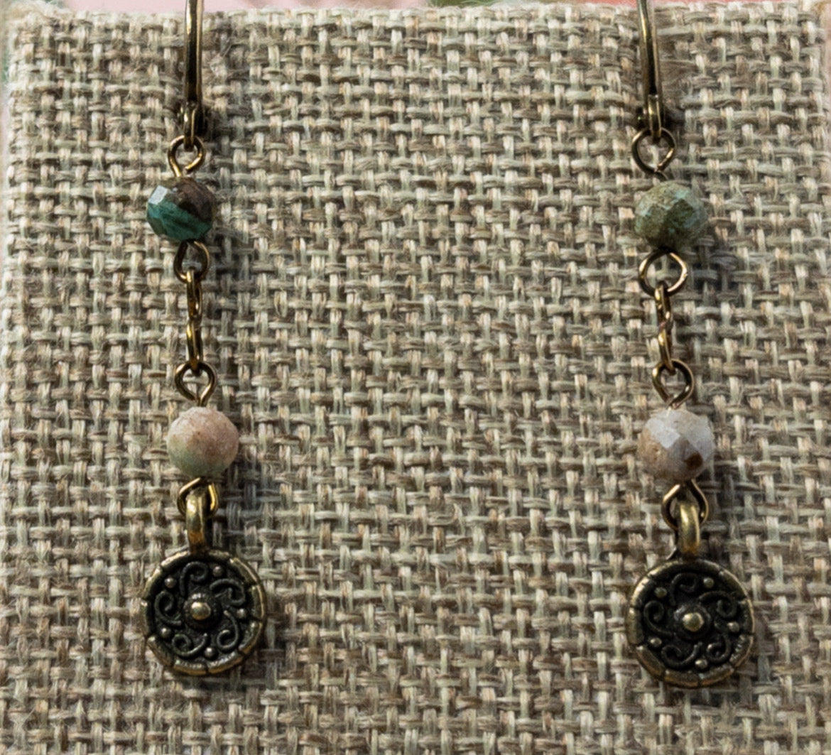 Measuring 1.5 inches in length, these earrings feature a beaded chain made from small faceted turquoise beads and are finished with an antique bronze flower charm. Huggie ear wires ensure your earrings are secure.