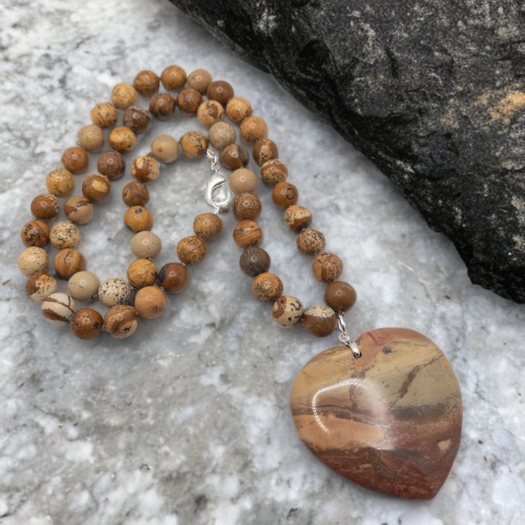 This is a hand knotted necklace made with 10 mm round picture jasper. It includes a heart shaped agate focal bead.