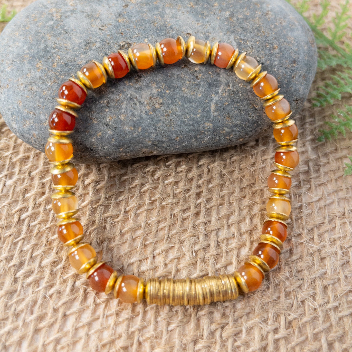 This bracelet is made with round carnelian beads and accented with brass crisper beads. The focal of the bracelet are the brass crisper beads.