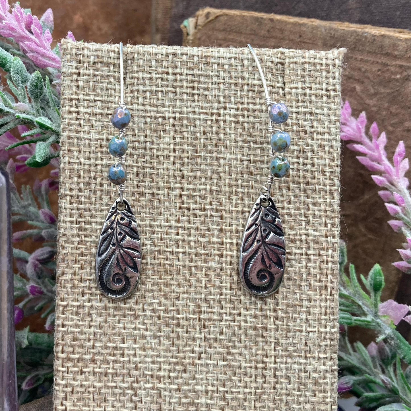 Silver tone marquis shaped ear wires are wire wrapped with Czech fire-polished faceted round alabaster and lazure blue beads. They include Tiera cast charm dangles.