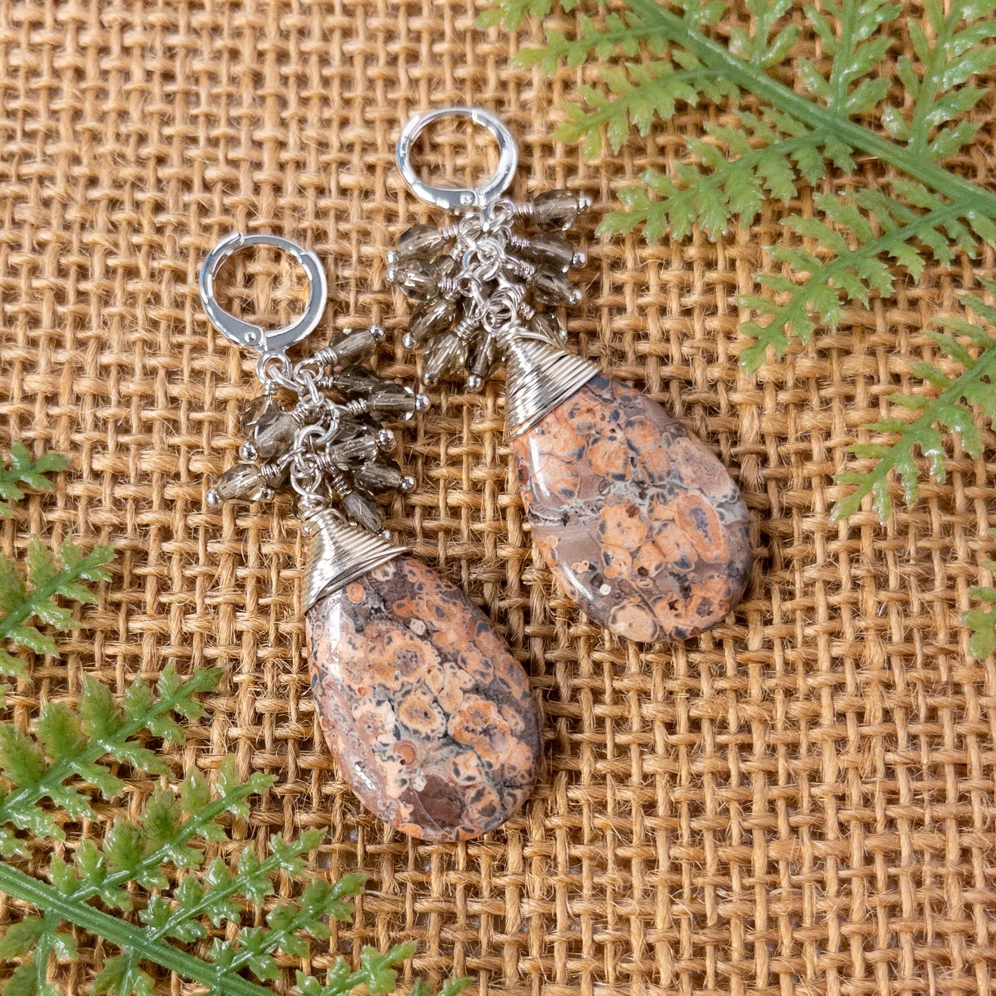 These are pear shaped beads with tones of light pink and brown. They are wire wrapped and include grey faceted Czech bead dangles