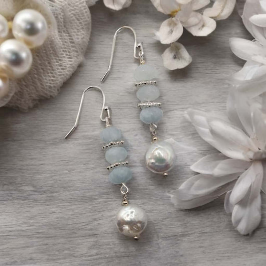 Rondelle shaped aquamarine beads hang from sterling silver ear wires and are accented with coin shaped fresh water pearls.