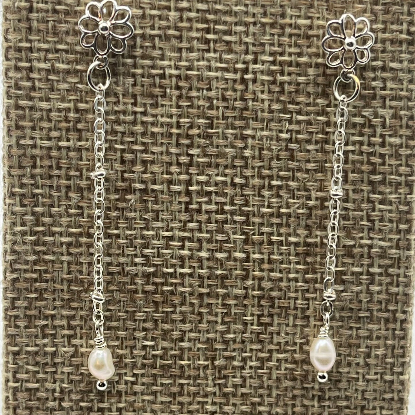 Small rice pearls are suspended on delicate silver tone chain. The earrings are approximately 2 inches in length
