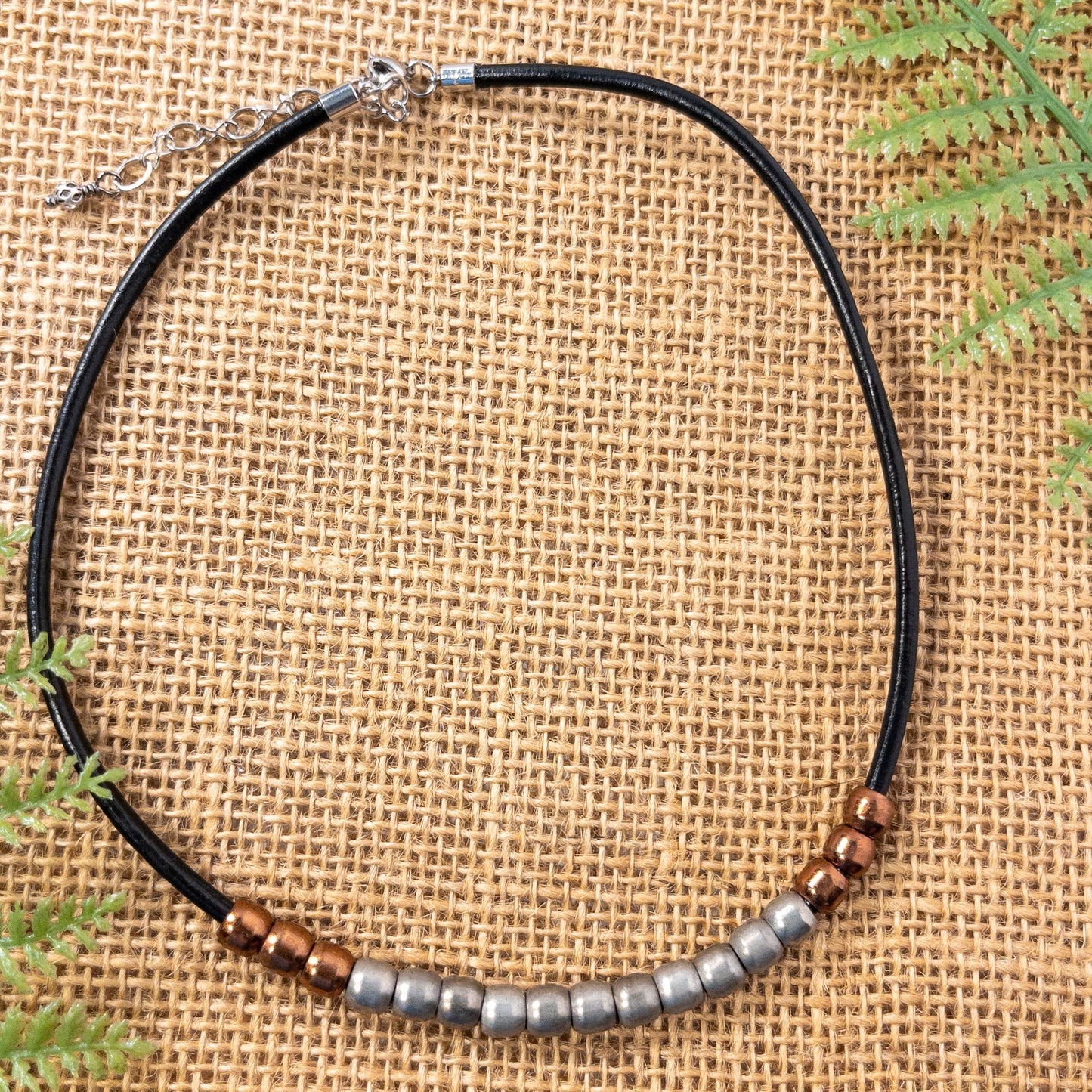 This necklace is made with 2mm black leather cord strung with copper and silver padre beads. The necklace includes a 2 inch extender.