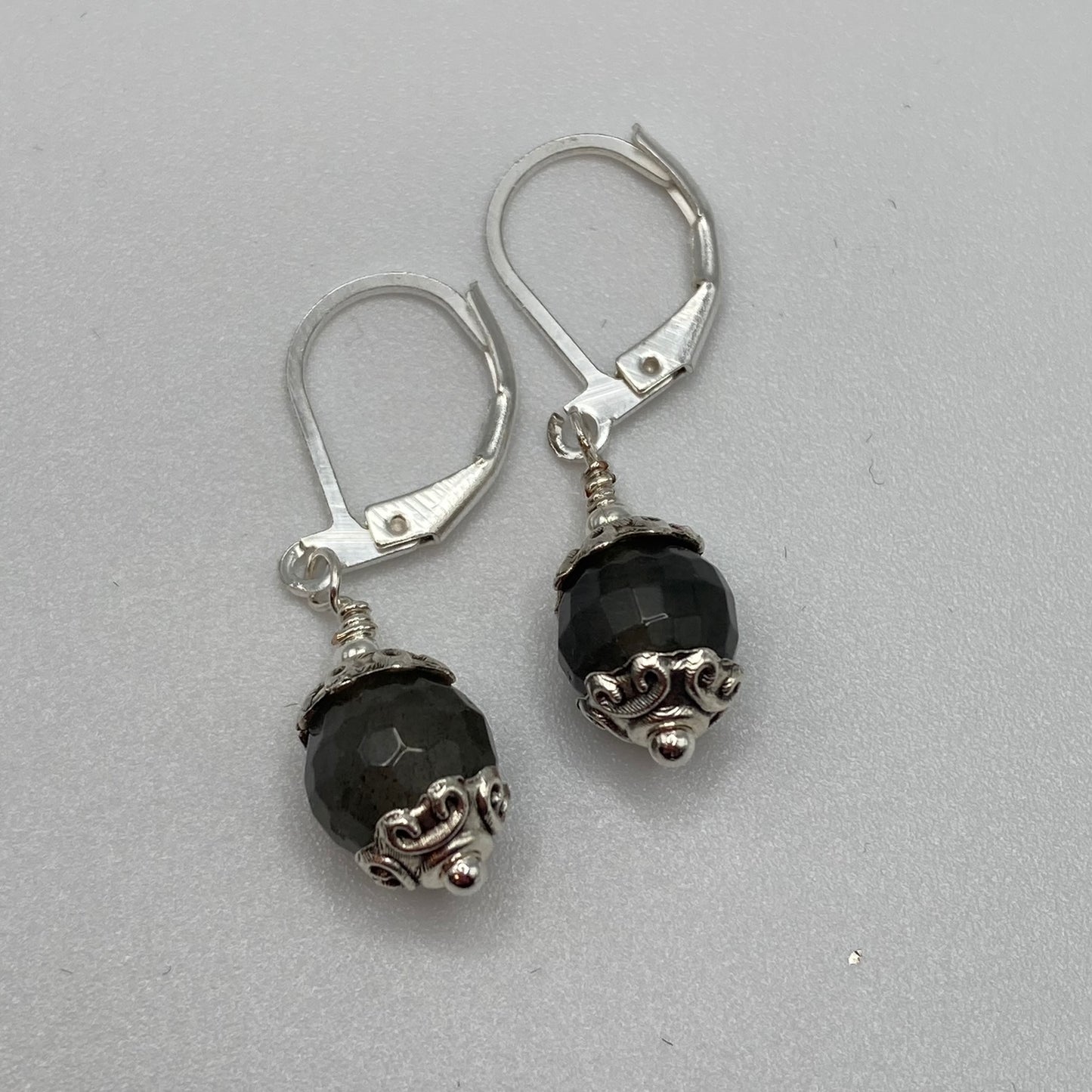 8mm faceted Labradorite beads are accented with silver bead caps and attached to lever back ear wires. Natural light enhances the beauty of the stone not captured in this picture