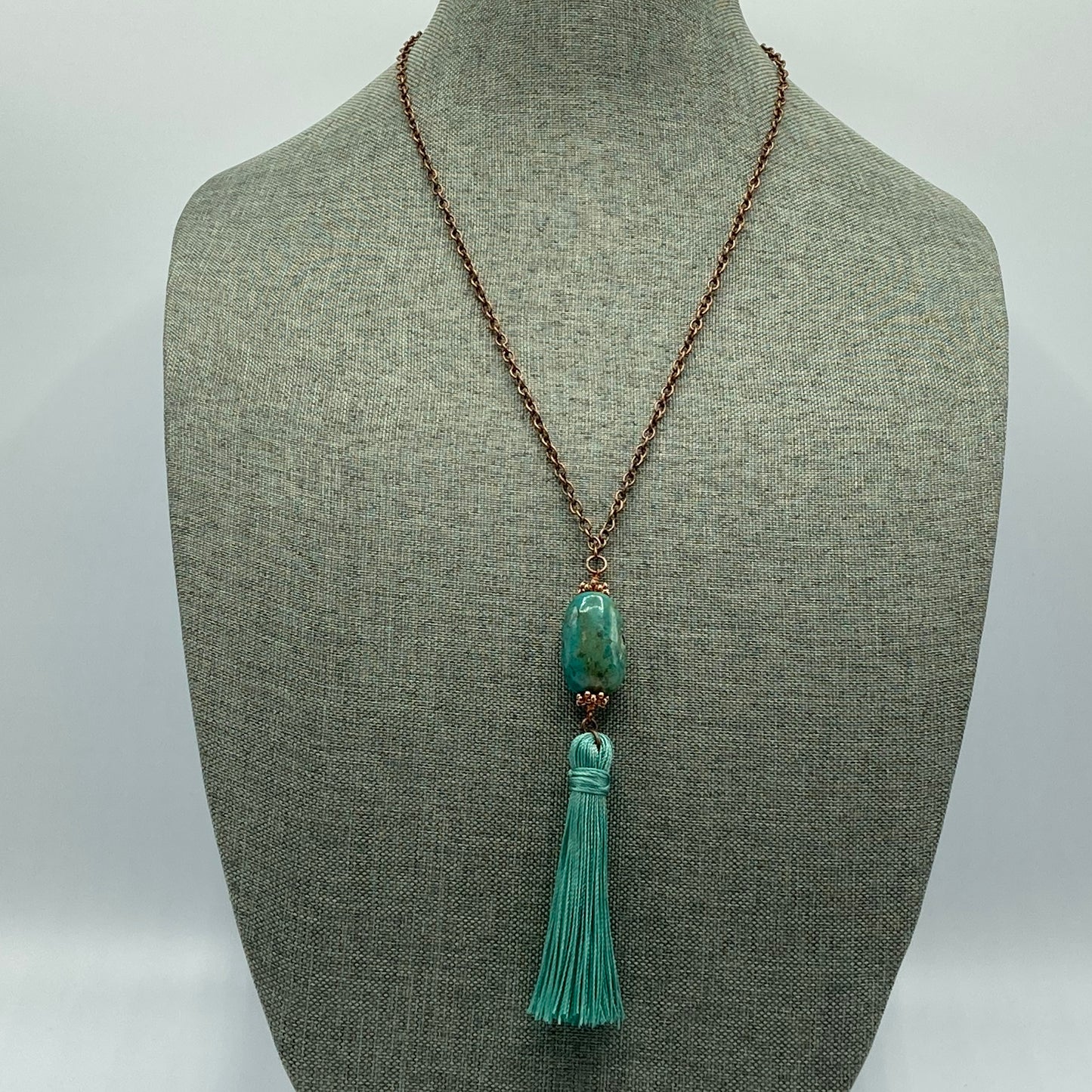 Copper-colored chain, Turquoise nugget bead, and a tassel create a simple statement necklace.