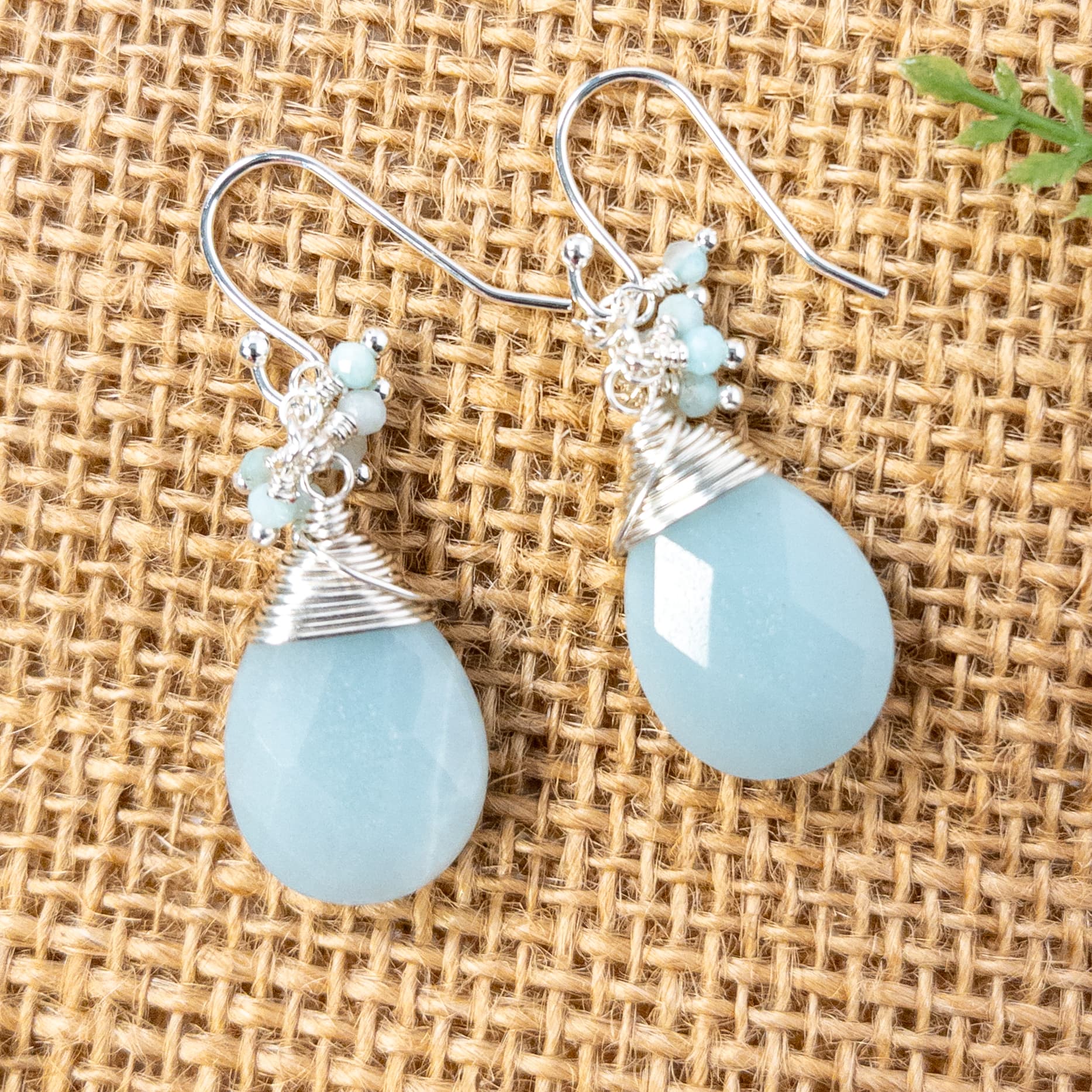 Crafted with anti-tarnish silver tone wire, these earrings feature teardrop shaped faceted Amazonite beads, accented with dangles of small round faceted Amazonite beads.  Sterling silver ear wires complete the pair.