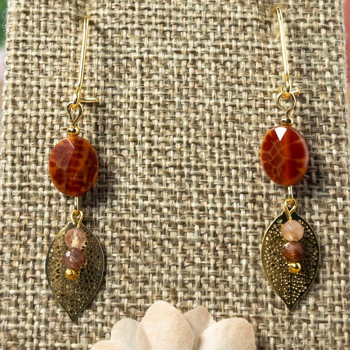 These 1.25 inch earrings feature stunning Faceted oval shaped Fire Agate gemstone beads and elegant filigree leaf charms, creating the perfect balance of delicate and eye-catching.