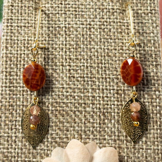 These 1.25 inch earrings feature stunning Faceted oval shaped Fire Agate gemstone beads and elegant filigree leaf charms, creating the perfect balance of delicate and eye-catching.