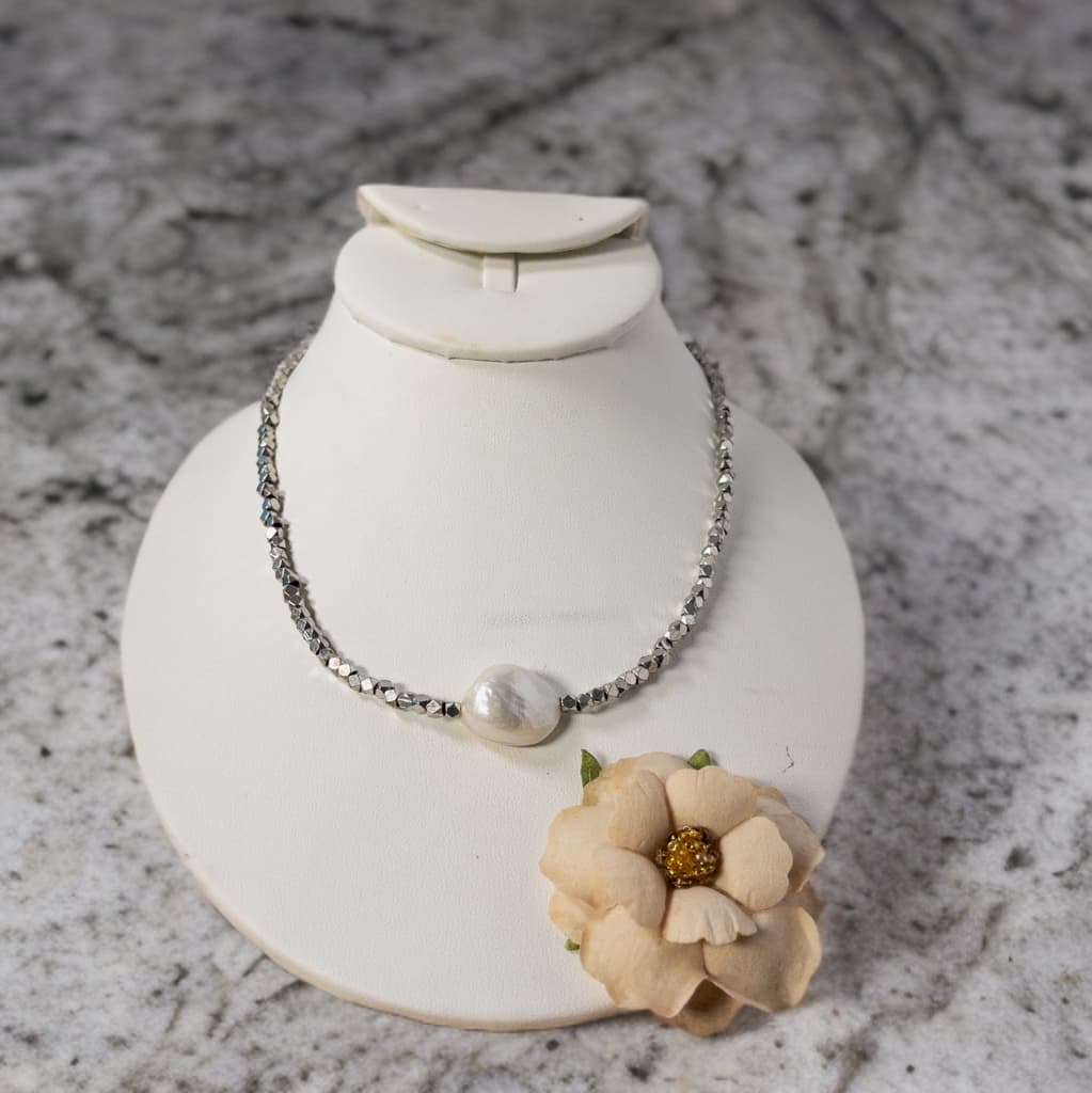 This necklace is 18 inches in length and includes a 2 inch extender.  It features a single large Baroque pearl surrounded by diamond cut silver metal beads. 
