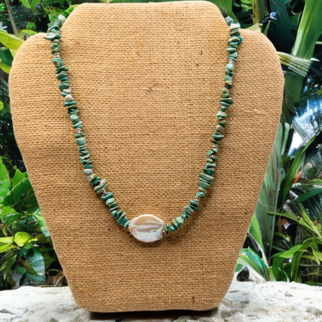 This necklace is 16 inches in length but includes a 2 inch extender.  It is made with turquoise chip beads and features a large baroque pearl focal.  