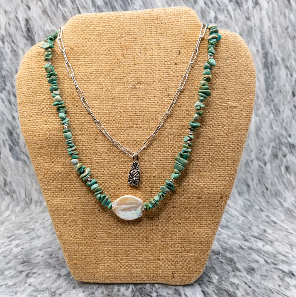 This depicts a layering option of the turquoise chip necklace with a simple paper clip chain charm necklace.  