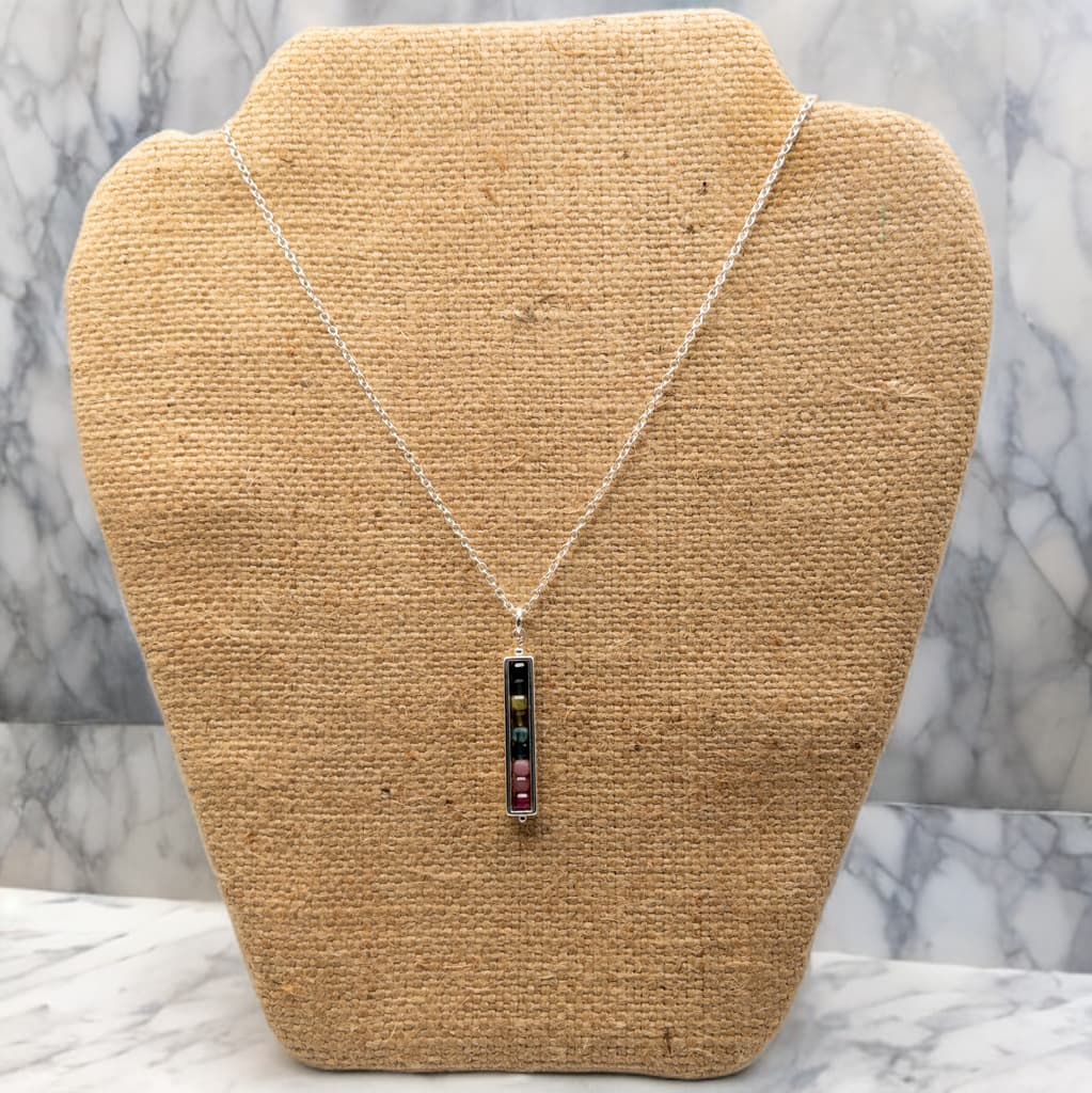 This is a 16 inch, but expandable to 18 inch length sterling silver cable chain necklace.  It includes a single pendant of cube shaped tourmaline beads enclosed in a silver tone rectangle bead frame. 