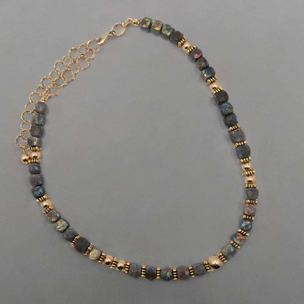 This necklace is made with faceted cube shaped Labradorite beads.  The luster and colors of the beads include deeps blues, greys and greens.  The round gold spacer beads compliment and highlight the color found in the beads.
