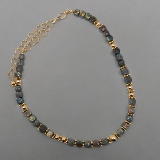 This necklace is made with faceted cube shaped Labradorite beads.  The luster and colors of the beads include deeps blues, greys and greens.  The round gold spacer beads compliment and highlight the color found in the beads.
