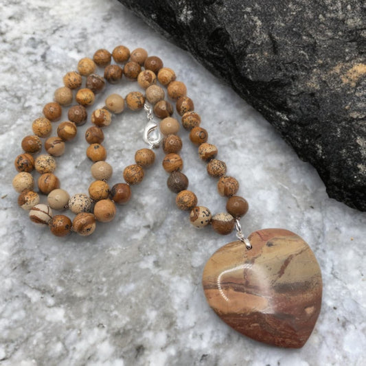 This is a hand knotted necklace made with 10 mm round picture jasper.  It includes a heart shaped agate focal bead.  