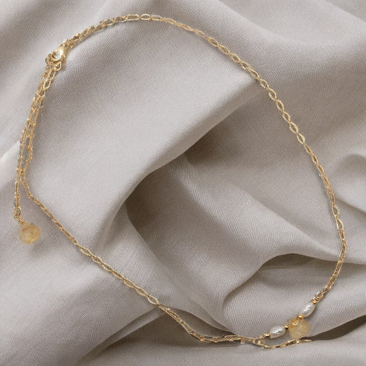This bar necklace features a tear drop Citrine faceted bead with rice pearls on either side.  It is strung on a dainty gold chain.
