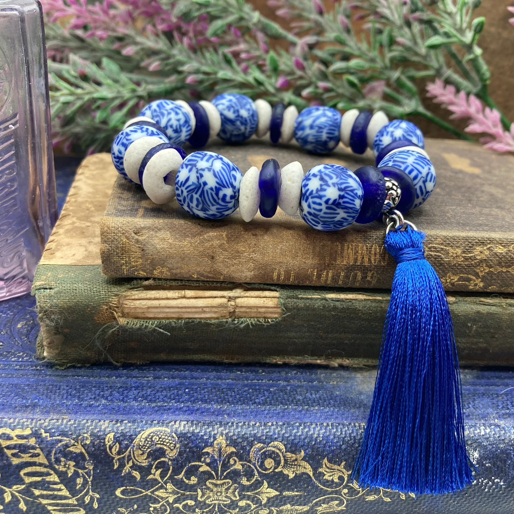 This bracelet is eco-friendly!  It is made from recycled glass round and saucer shaped beads.  The large round blue and while round beads are separated by white and royal blue saucer shaped beads.  The bracelet is accented with a blue tassel.