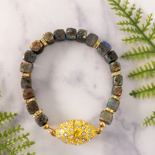 A bracelet made with faceted cube shaped labradorite beads and square pave crystal spacers.  The magnetic clasp is gold with crystals