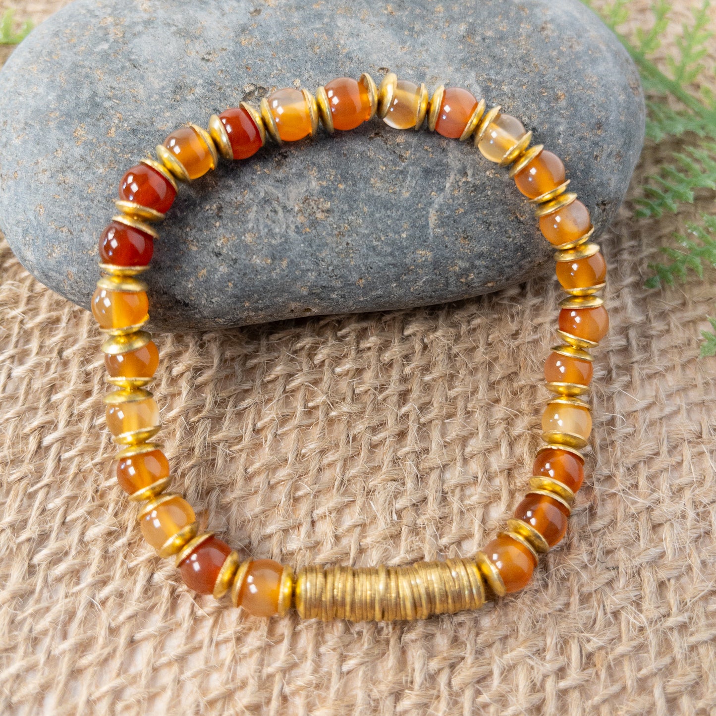 This bracelet is made with round carnelian beads and accented with brass crisper beads.  The focal of the bracelet are the brass crisper beads. 