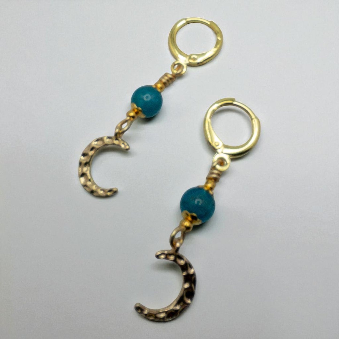 Gold huggie earrings with a single apatite bead and hammered half moon charm
