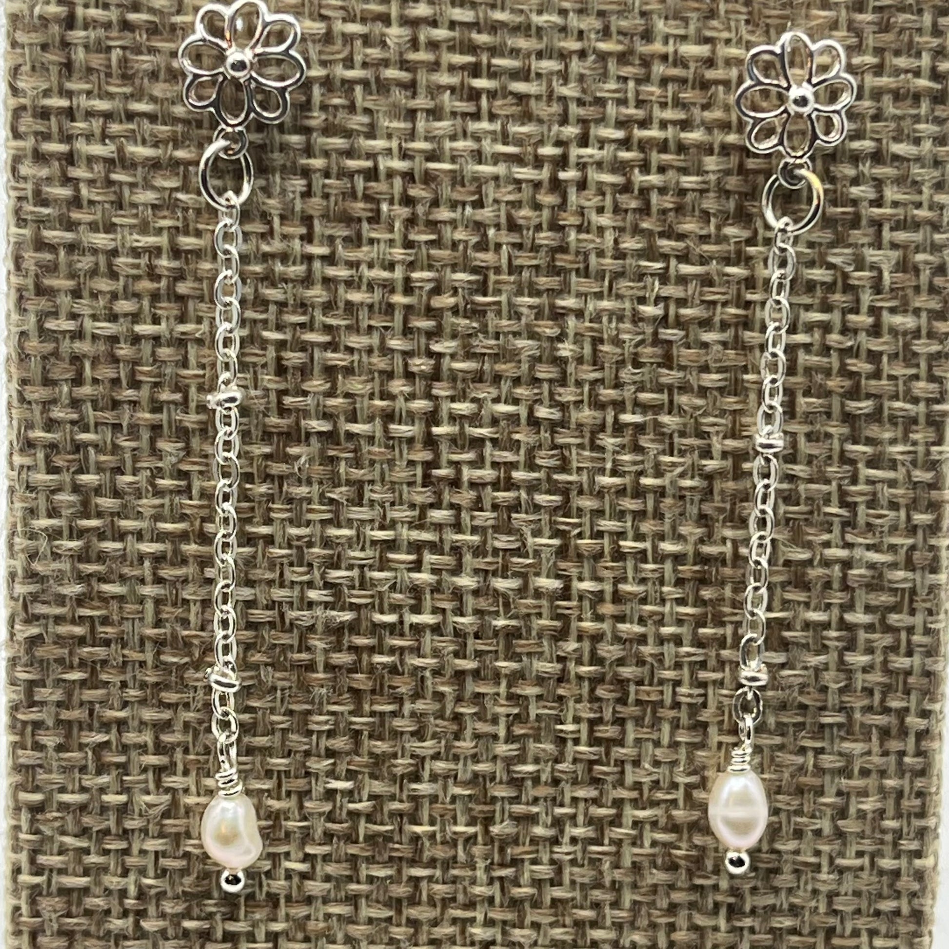 Small rice pearls are suspended on delicate silver tone chain.  The earrings are approximately 2 inches in length