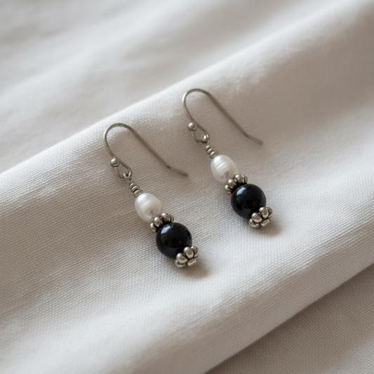 Pair of earrings with freshwater pearl and black onyx bead suspended from sterling silver ear wires