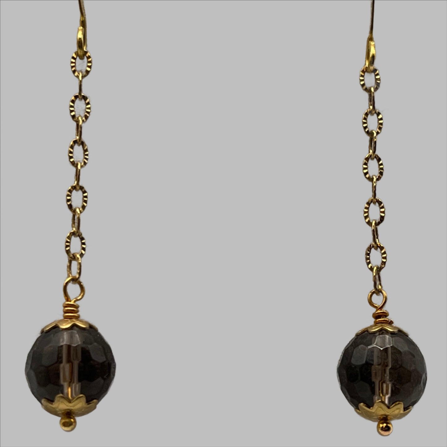 Faceted 10mm smokey quartz gemstones suspended from gold tone chain.  