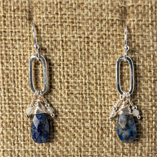 The faceted tear drop shaped beads, suspended from a paperclip chain, add a touch of sophistication. The complementary blue and silver tones enhance the beauty of the lapis, known for its calming and healing properties. Completed with sterling silver ear wires.