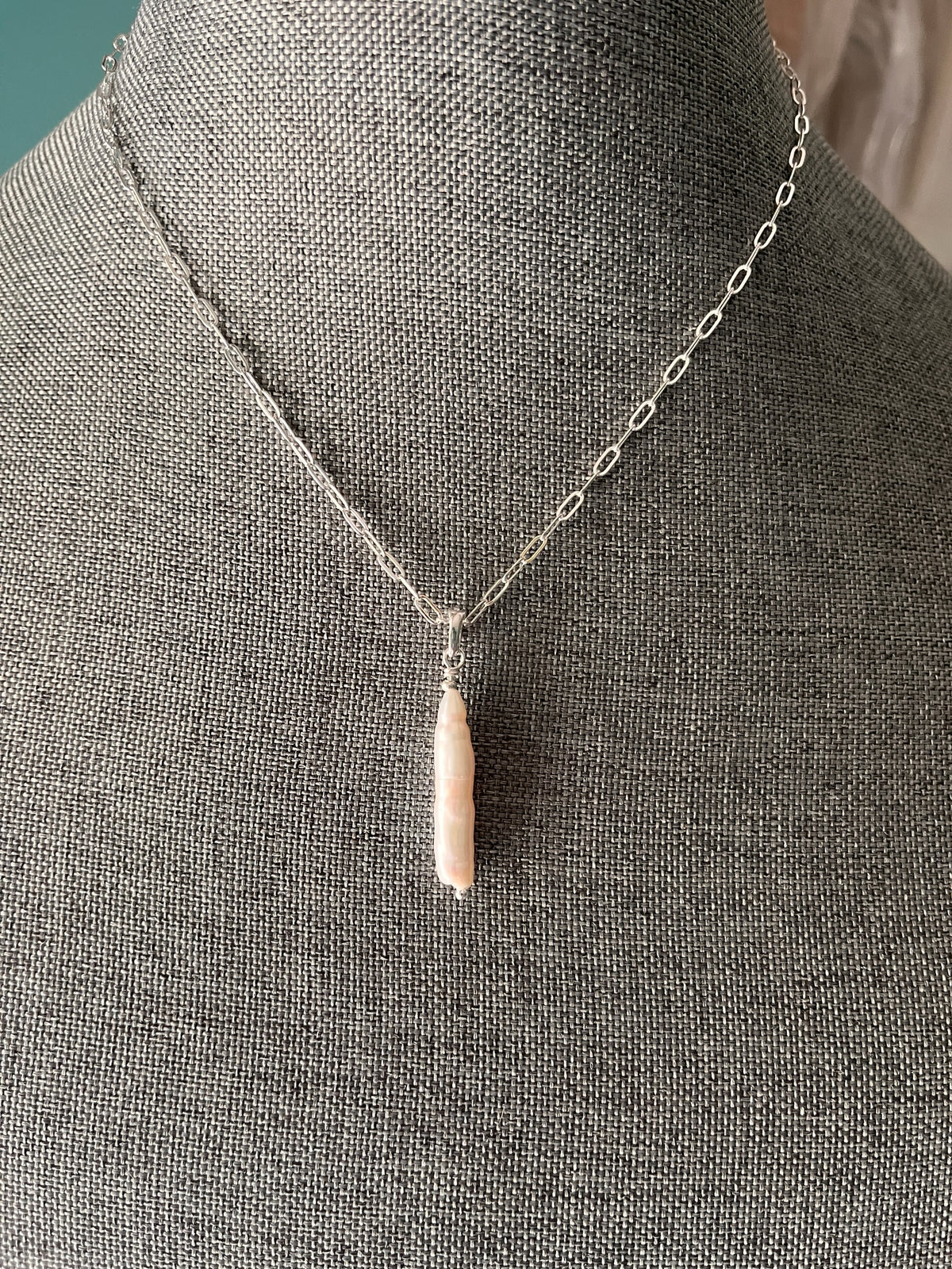 Blakeley Lane Jewelry elongated stick pearl pendant on a delicate silver link chain displayed on a grey mannequin