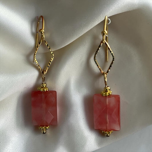 Blakeley Lane Jewelry gold geometric drop earrings with faceted rose-hued rectangular stones on a silk background.