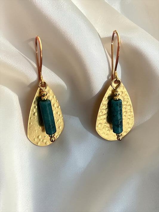 Blakeley Lane Jewelry hammered gold-tone teardrop dangle earrings with deep teal stone beads on a white silk background.
