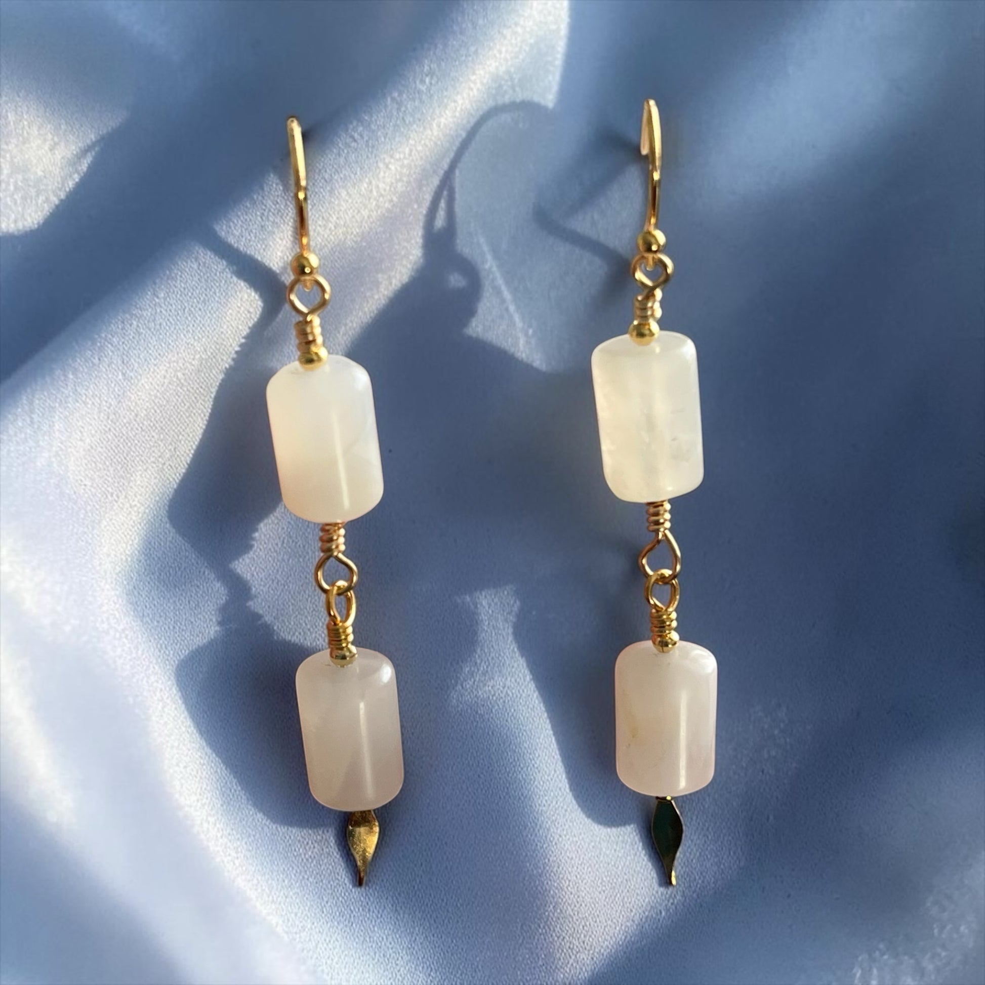 Blakeley Lane Jewelry double drop earrings with rectangular moonstone beads and gold-tone accents on blue silk.