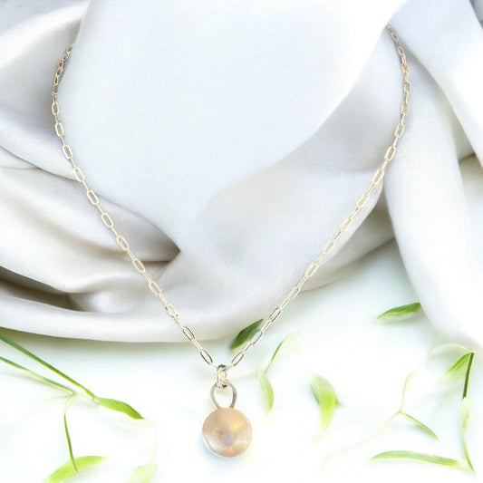 Blakeley Lane Jewelry minimalist necklace with a lustrous pearl pendant on a gold-tone paperclip chain on silk fabric.