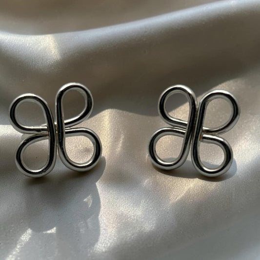 Blakeley Lane Jewelry silver-toned sculptural loop stud earrings with a polished clover-inspired open-work design.