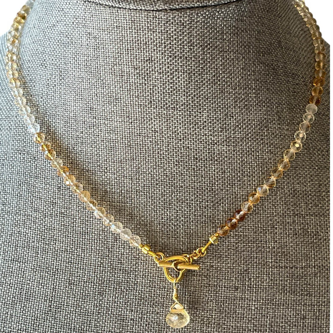 Necklace with a pendant on a gray mannequin bust