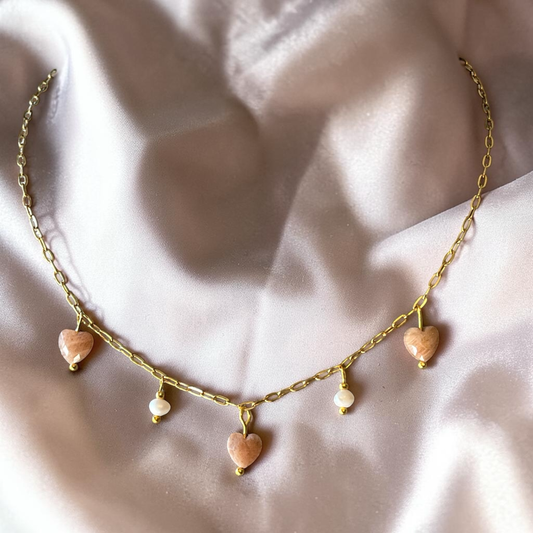 Necklace with heart-shaped pendants on a soft fabric background