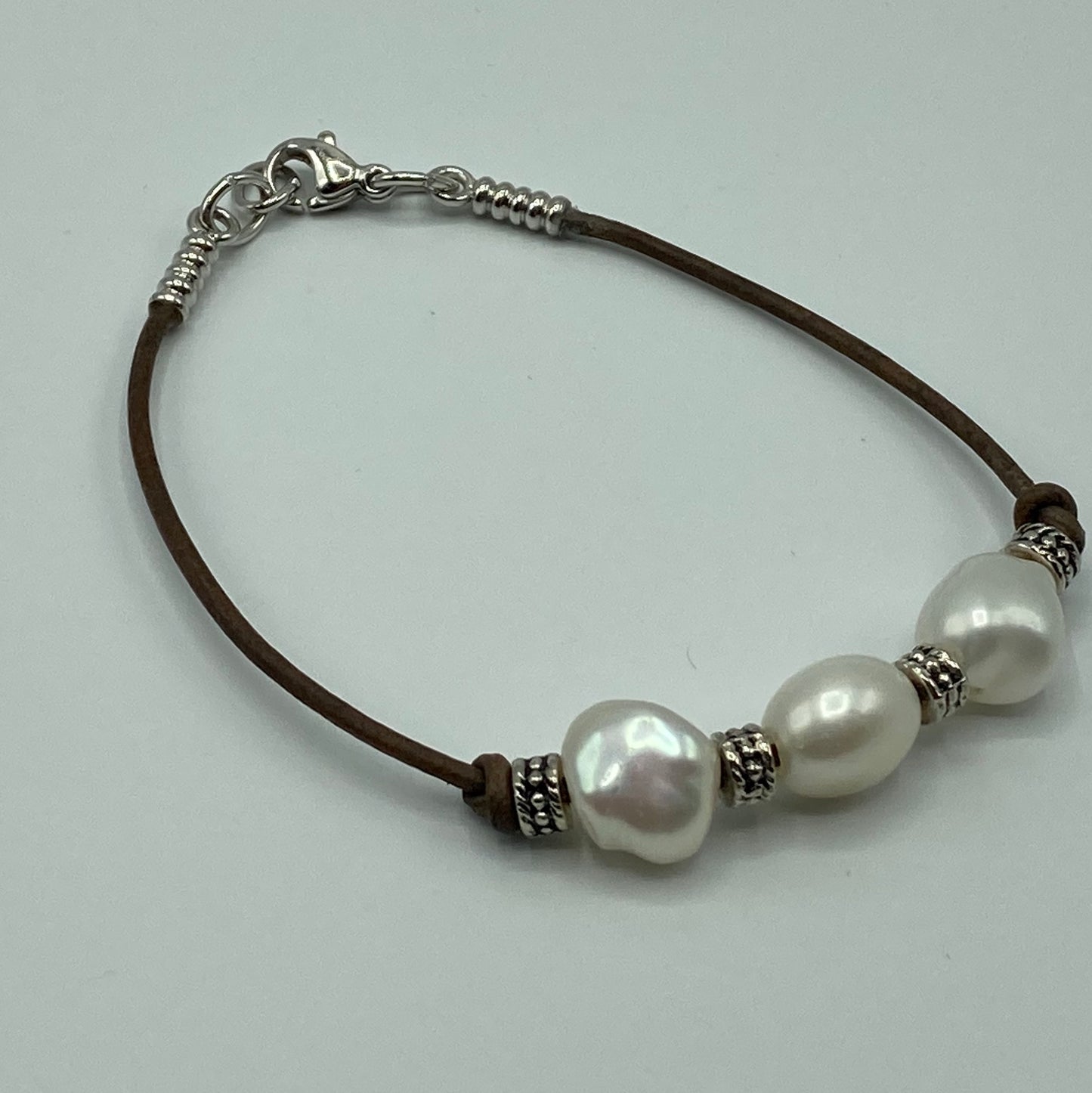 This bracelet is made with 1.5mm leather cord and is embellished with pearls and silver spacer beads. It fits a size 7 wrist but an expander can be added to accommodate larger wrist sizes.