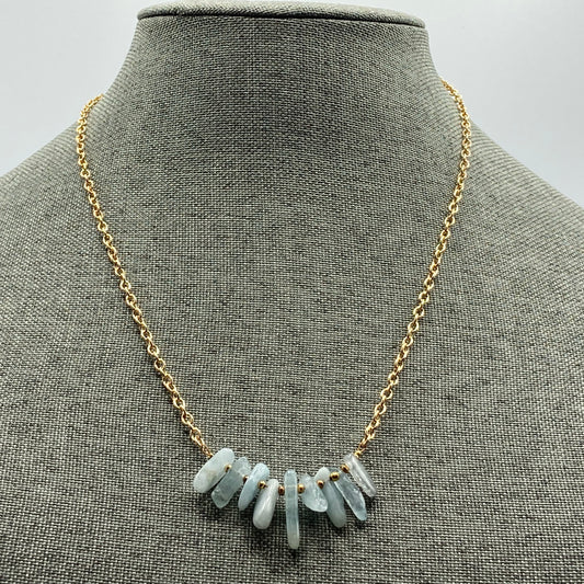 This necklace is 20 inches in length and includes a 1.25" extender. It is made with Aquamarine chip beads and is strung on a gold-colored chain.