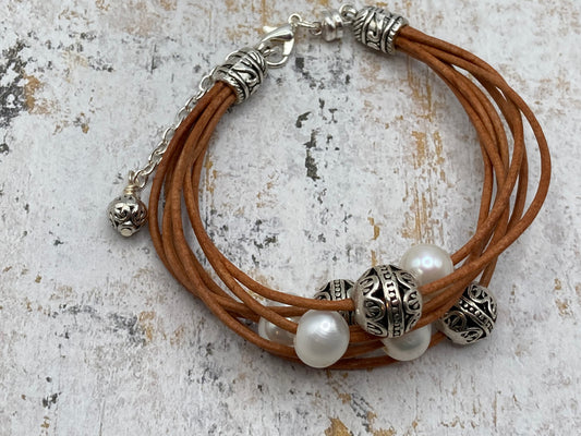 This bracelet is made with leather cord, large-hole pearls, and metal beads. It includes a magnetic clasp and an extender clasp. Once you select your proper size, the bracelet can easily be put on and taken off using the magnetic clasp.