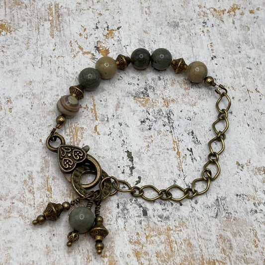 This bracelet is made with 6mm Silver Leaf Agate beads, and an antique bronze chain, and is accented with several bead and metal dangle charms.  The bracelet fits up to a 7.5-inch wrist.