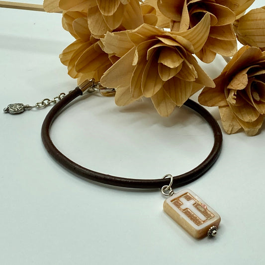 Bracelet is made with 2mm brown leather with a Czech glass cross dangle. It also includes an expander which accommodates for multiple wrist sizes.