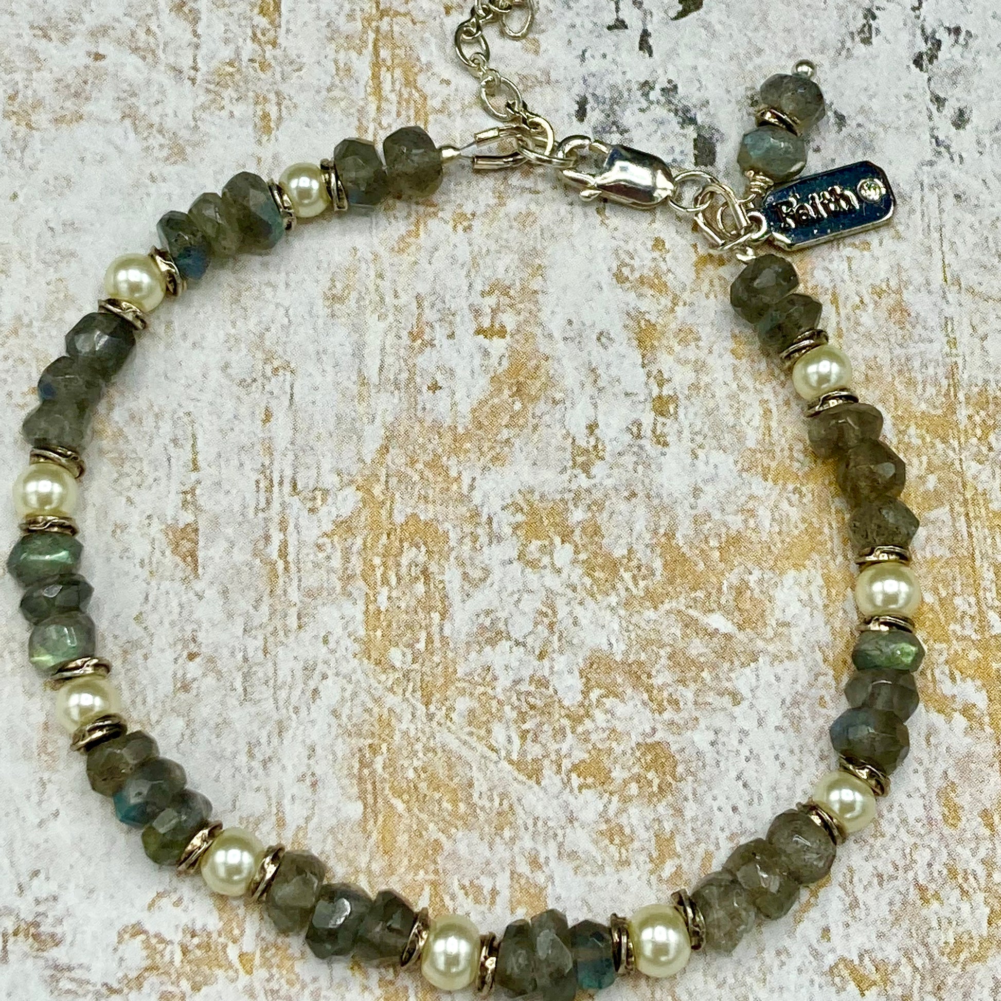 This piece is made with Labradorite rondelles, tiny pearls, and love-knot-spacer beads, creating a dainty and delicate bracelet. The extender clasp allows for multiple wrist sizes.