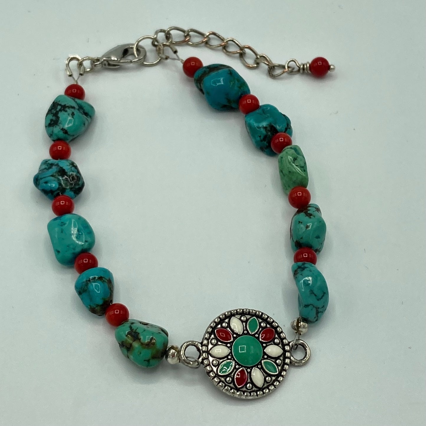 Bracelet is made with Turquoise and Coral chip stones and accented with a southwestern-inspired focal bead. It includes a lobster clasp and expander chain which will accommodate multiple wrist sizes.