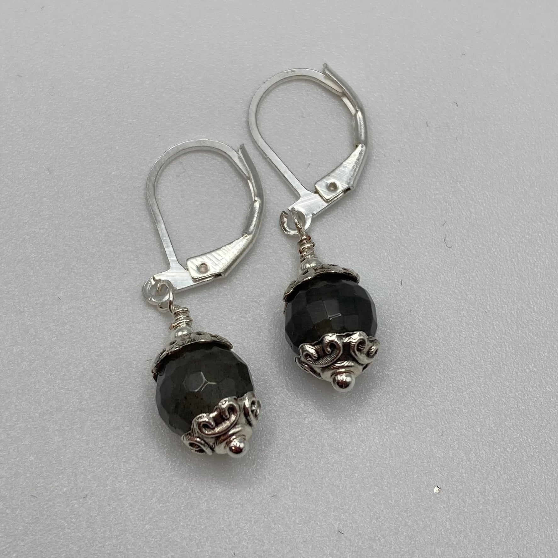 8mm faceted Labradorite beads are accented with silver bead caps and attached to lever back ear wires.  Natural light enhances the beauty of the stone not captured in this picture