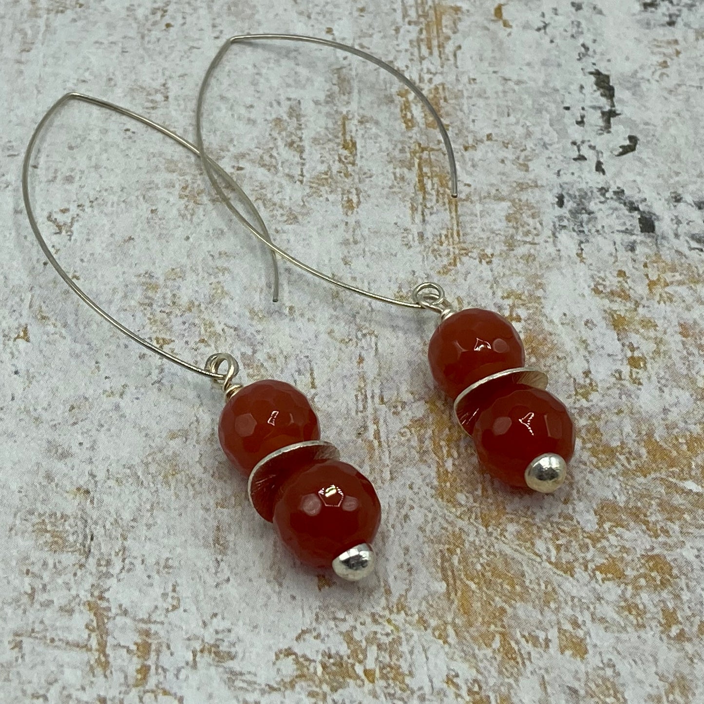 Earrings are made with Red Agate beads, silver disc spacers, and silver tone button top headpins.