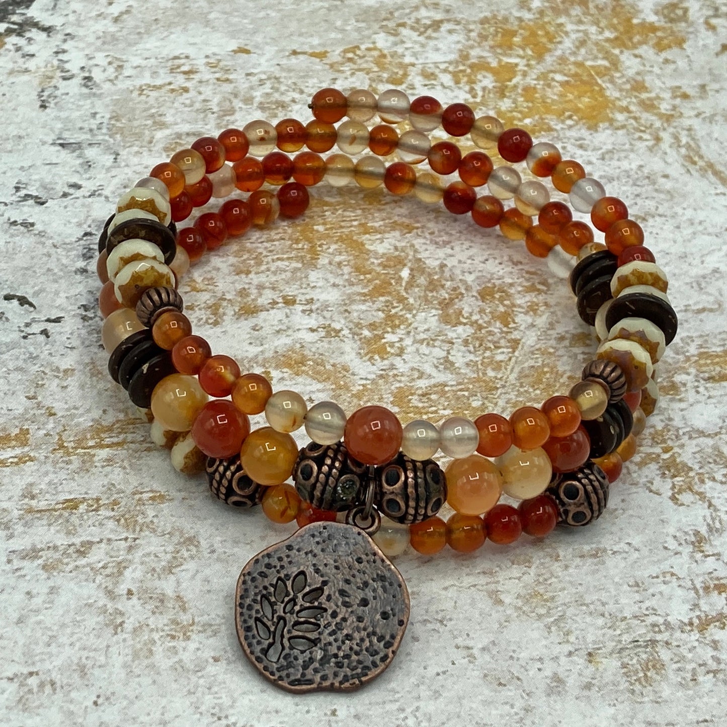 This is a 3 wrap memory wire-style bracelet that includes carnelian beads and Indonesian-inspired copper accent beads.