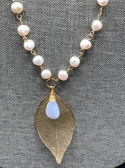 This necklace is approximately 36" long and includes freshwater pearls and a gold filigree leaf focal accented with a Lace Agate wire-wrapped briolette.