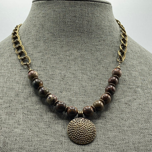 This necklace is made with 10mm Agate beads and an antique bronze hammered-style round pendant. The necklace measures approximately 18" and includes a 2" extender chain.